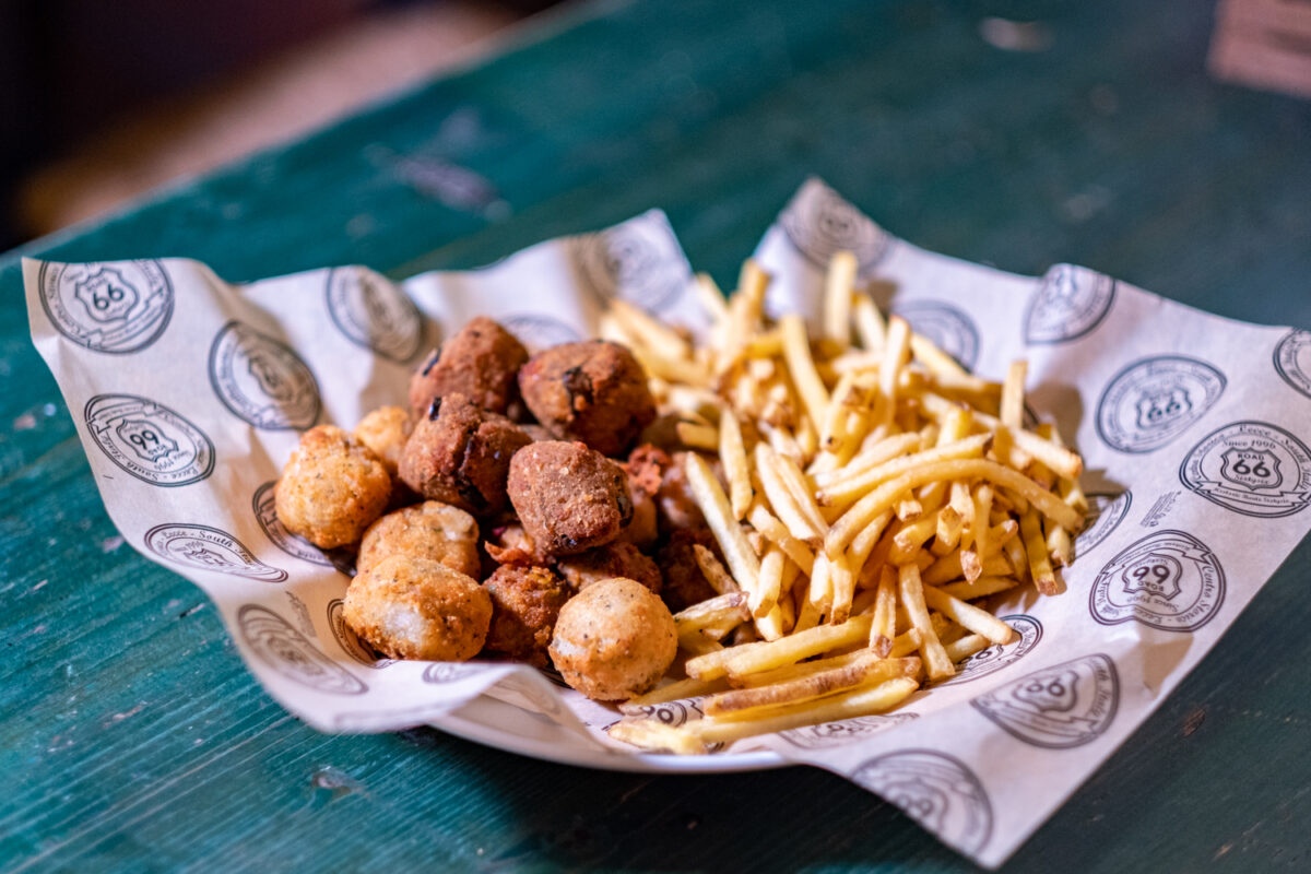 Frittini misti impanati e patatine fritte serviti insieme nella carta stampata del Road 66